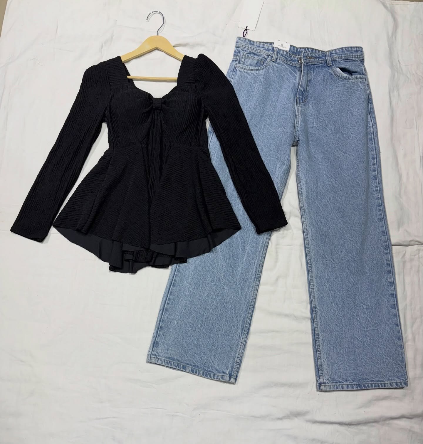 “Effortless Chic: Black Peplum Top with Wide-Leg Denim Jeans”