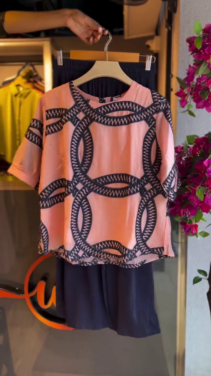 “Chic & Coordinated: Styling a Pink Patterned Top with Dark Trousers”