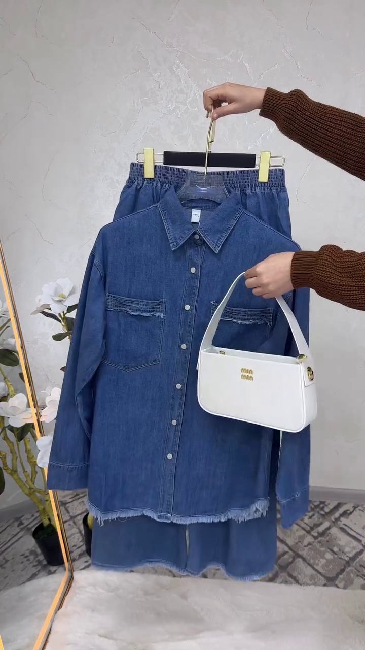 “Denim Details: Chic Frayed Shirt and Coordinating Trousers with a White Handbag”
