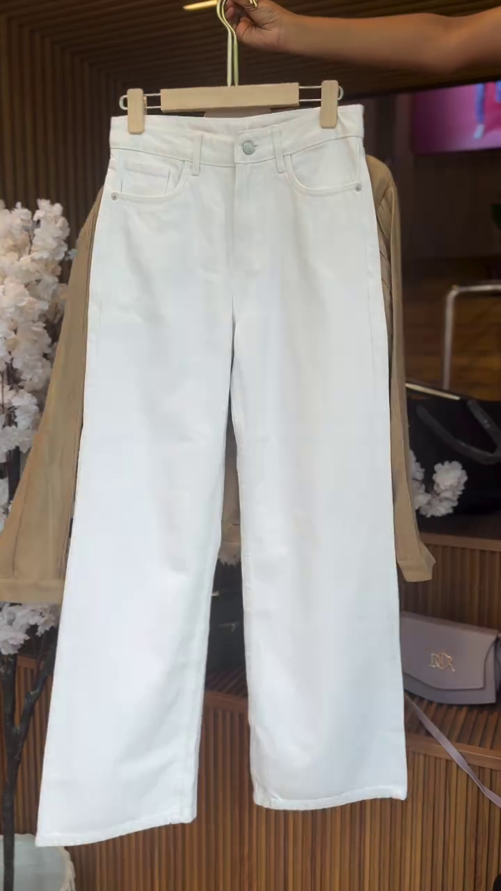 “Layered Chic: Button-Up Shirt over a Striped Tank with White Trousers”